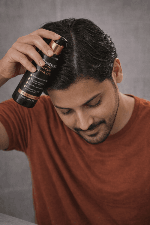 Rootsyra Herbal Hair Oil being pumped from the bottle onto the scalp during application.